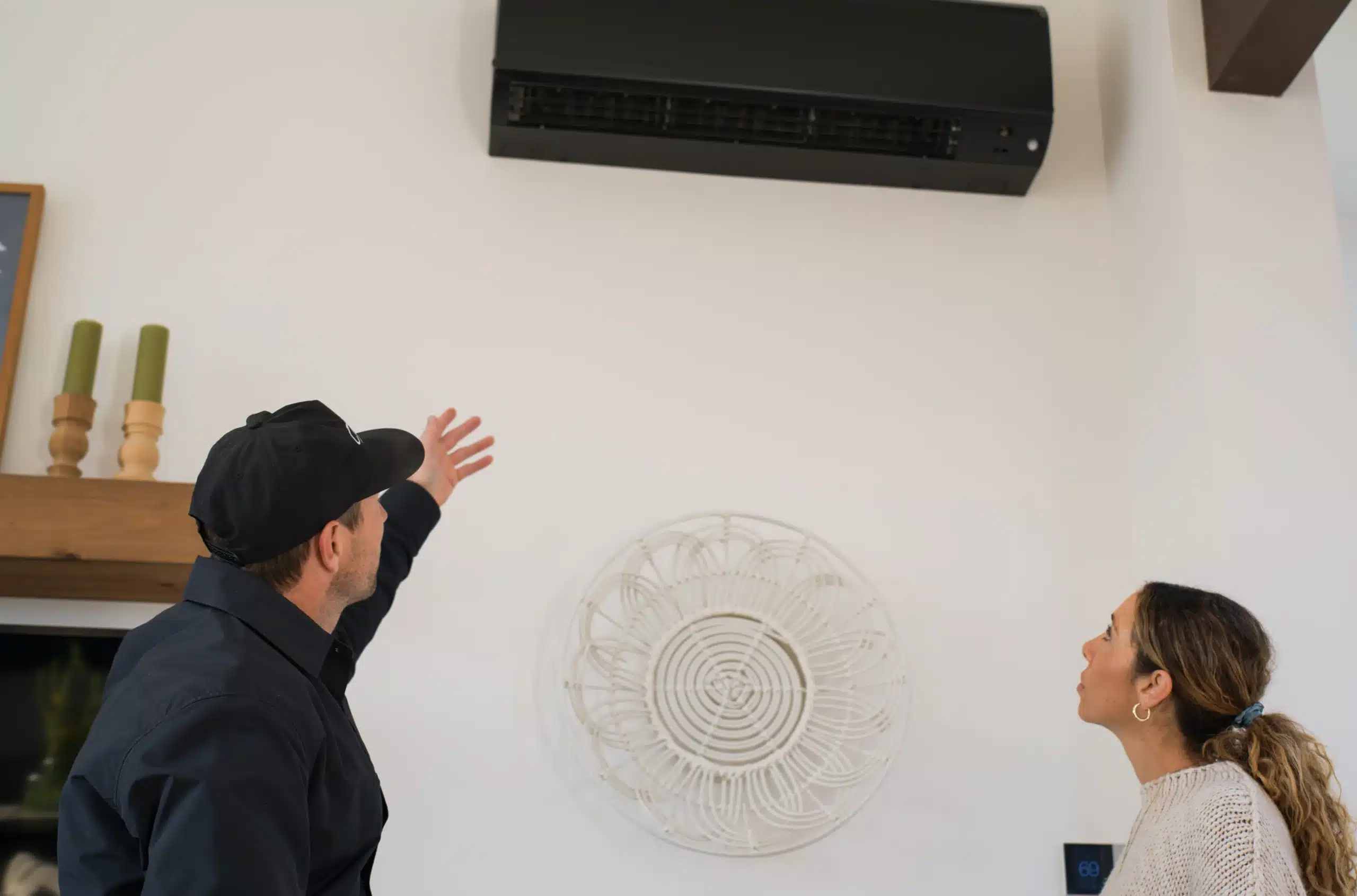 Thomson technician showing a homeowner a wall-mounted ductless unit