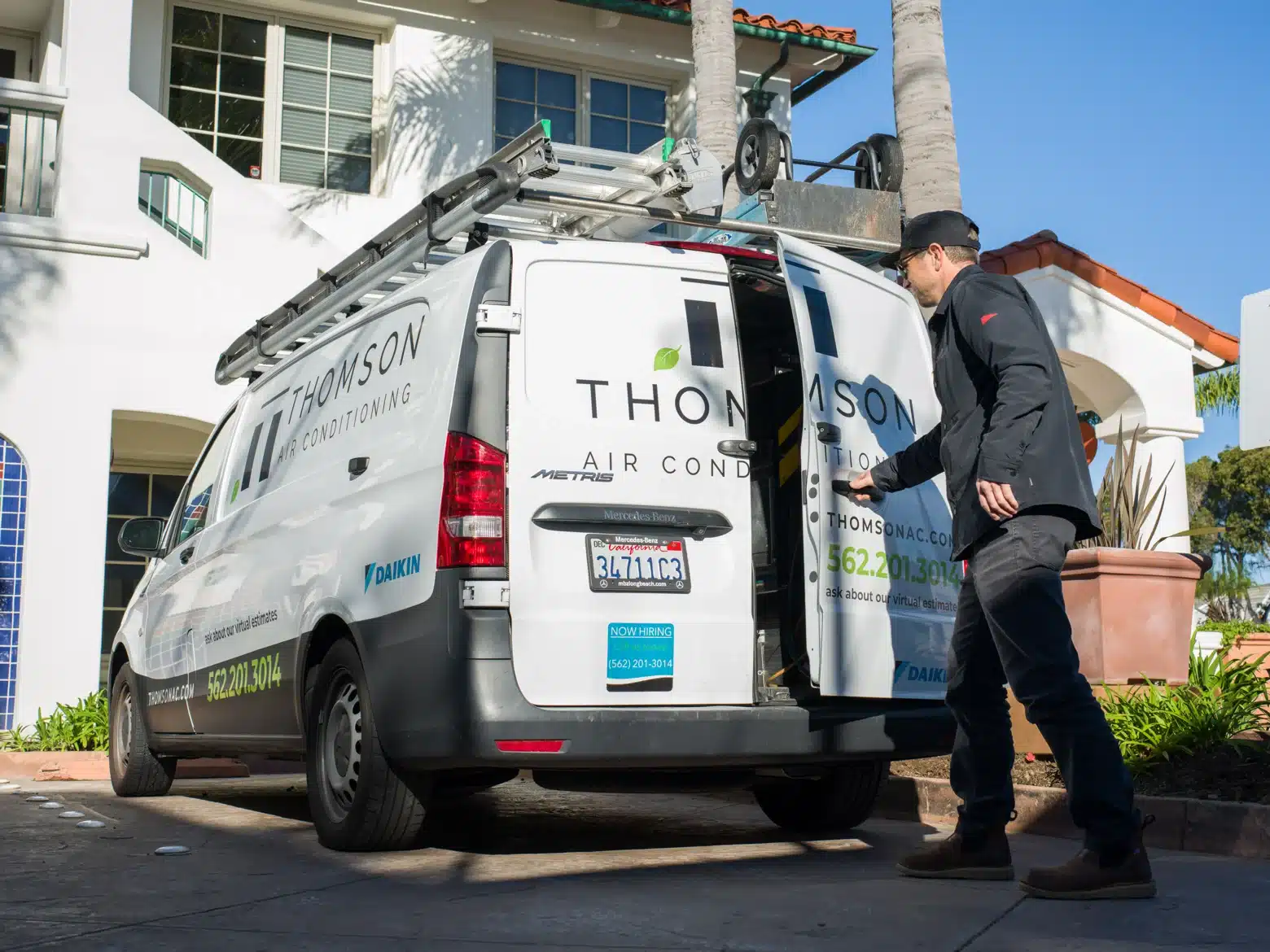 Thomson technician beside a branded service van