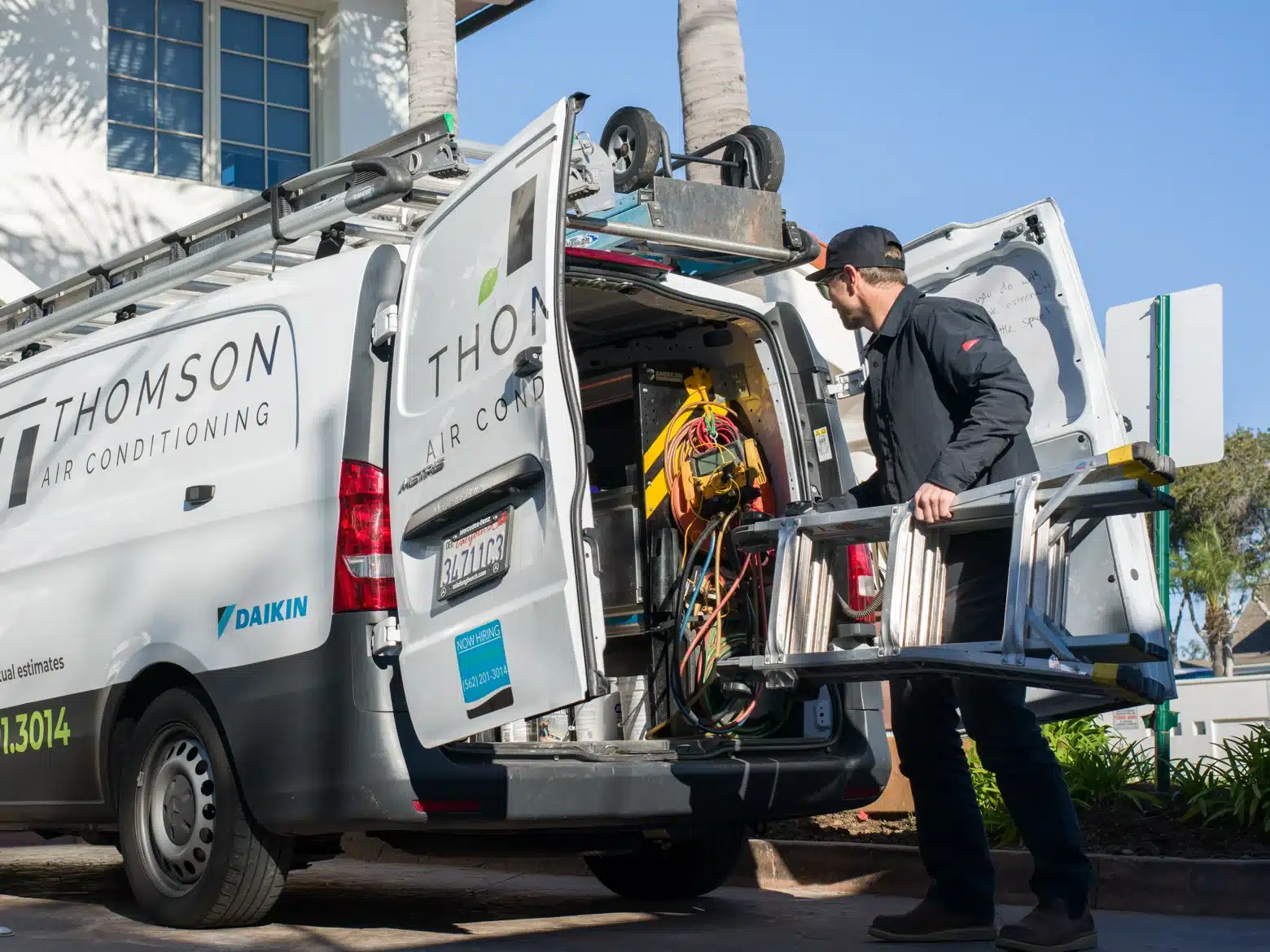 Thomson technician preparing equipment beside a service van