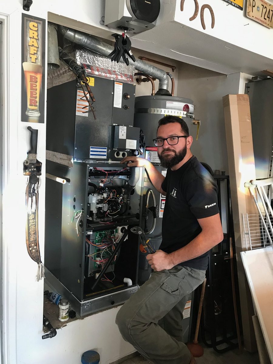 Thomson AC technician with a newly installed furnace in a Huntington Beach garage